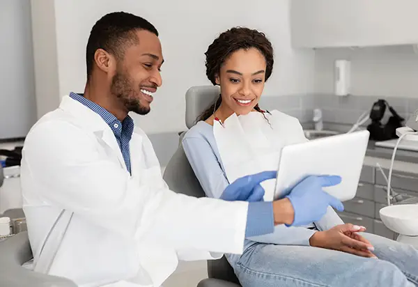 Dentist showing female patient results on a tablet at Cascadia Family Dental in Bend, OR.