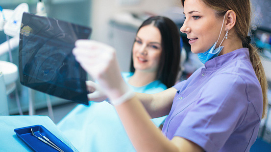 GettyImages-619655450 Dentist's assistant showing patient wisdom teeth x-rays during consultation at Cascadia Family Dental in Bend, OR.